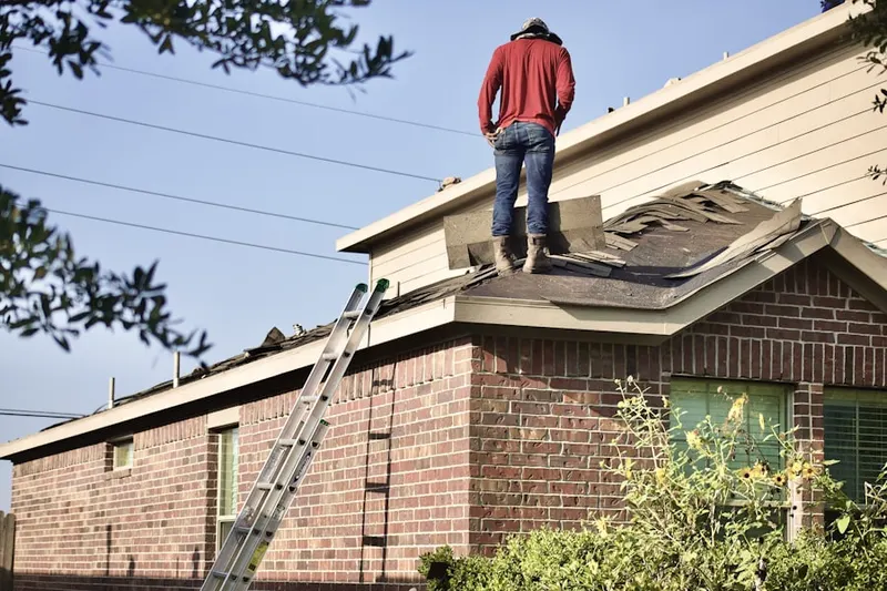 Professional roofer working on a residential roof in Hallmark-Camelot